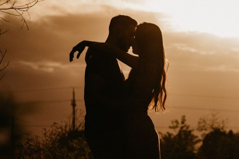 Coppia che si abbraccia al tramonto, simbolo di anime gemelle e connessioni karmiche tra segni zodiacali.